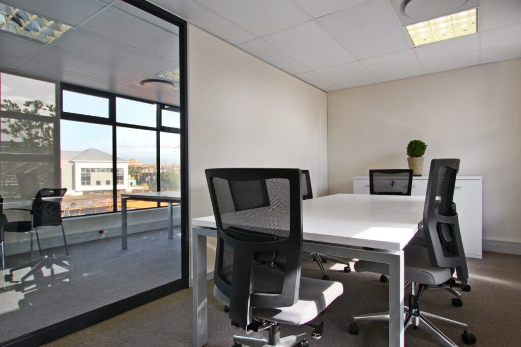 A meeting table with mesh back chairs in a glass walled office at Yield Capital, by Nuwave