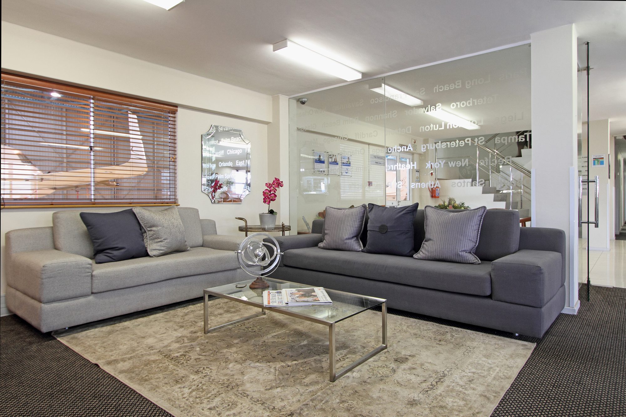 The passenger lounge with grey sofas and a glass table at Signature Flight Support, Cape Town Airport, by Nuwave
