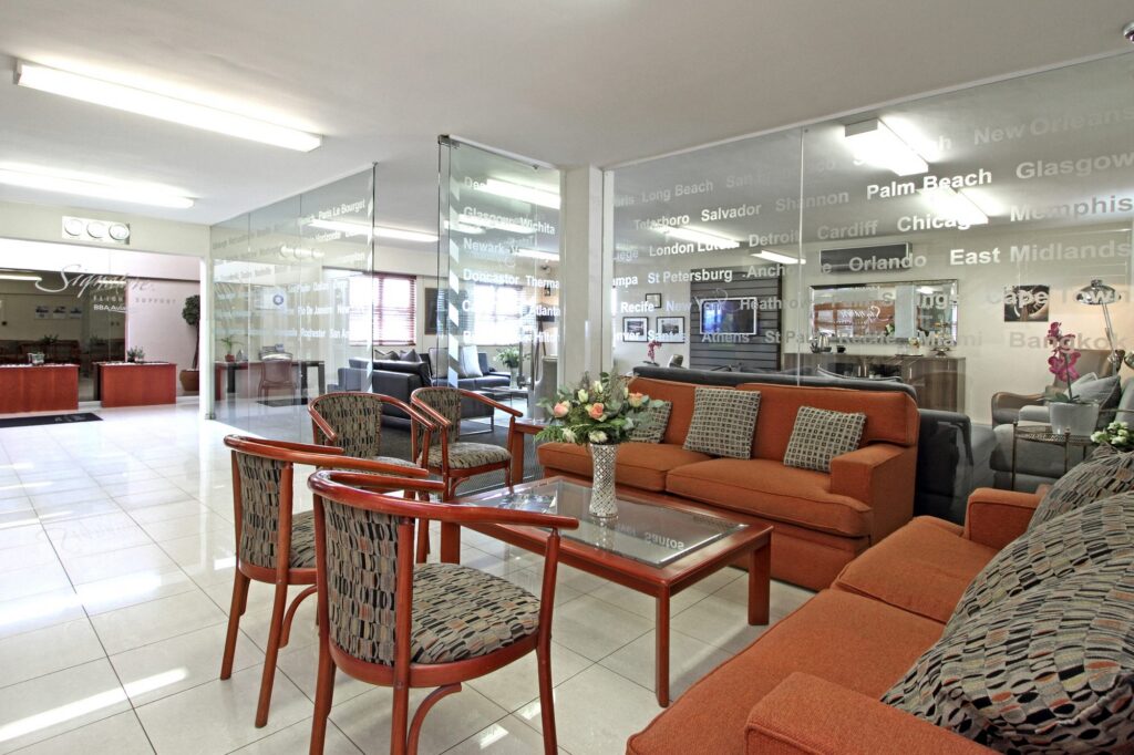 Lounge seating with orange sofas and a table at Signature Flight Support, Cape Town Airport, by Nuwave