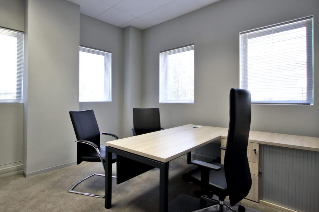A private office with an executive desk and visitor chairs at New Approach Medical, by Nuwave