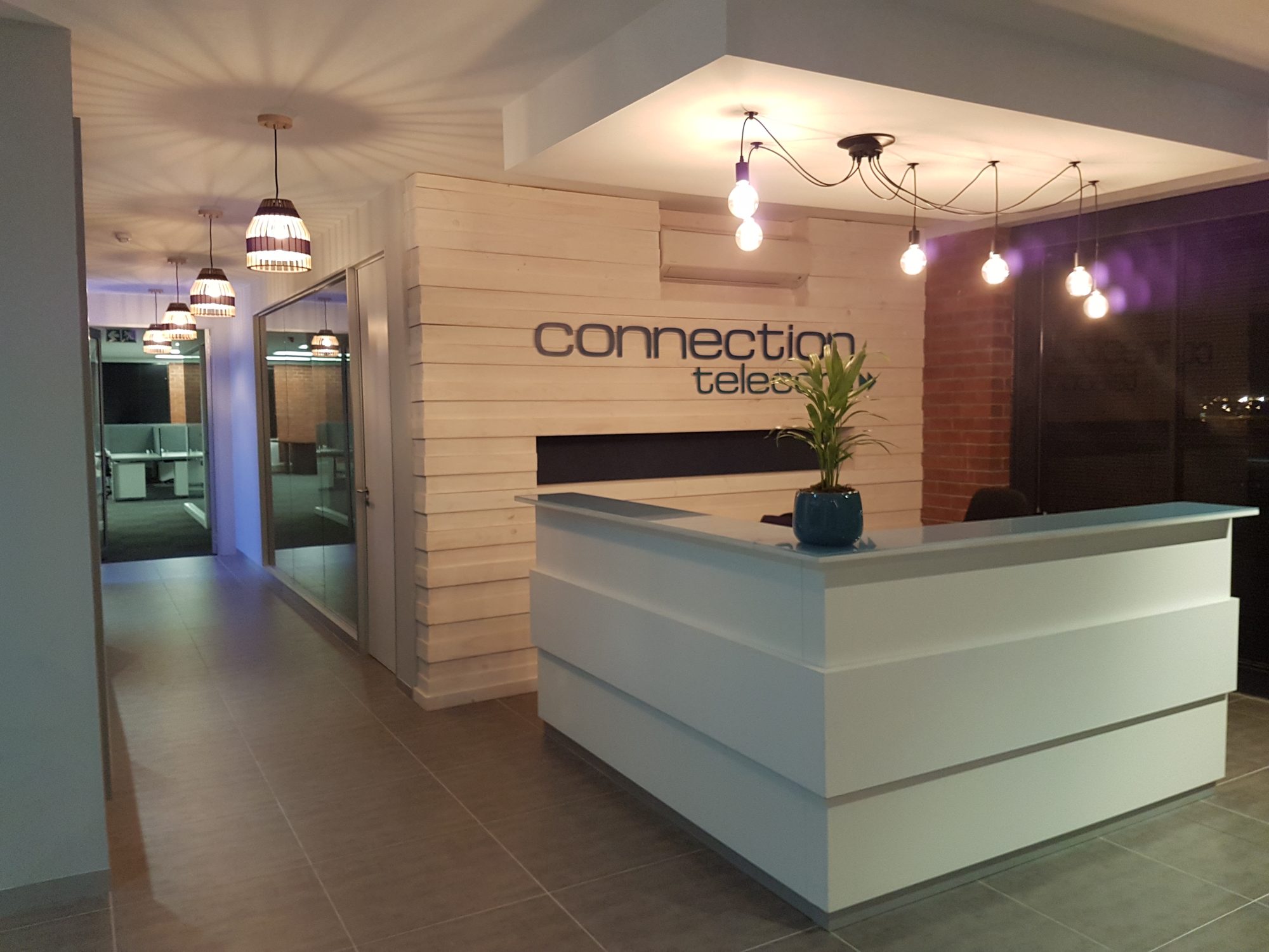 The timber reception counter under the Connection Telecom logo in Cape Town, furnished by Nuwave