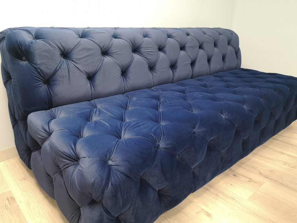 A blue button tufted sofa in the Nordex Energy waiting area in Cape Town, supplied by Nuwave