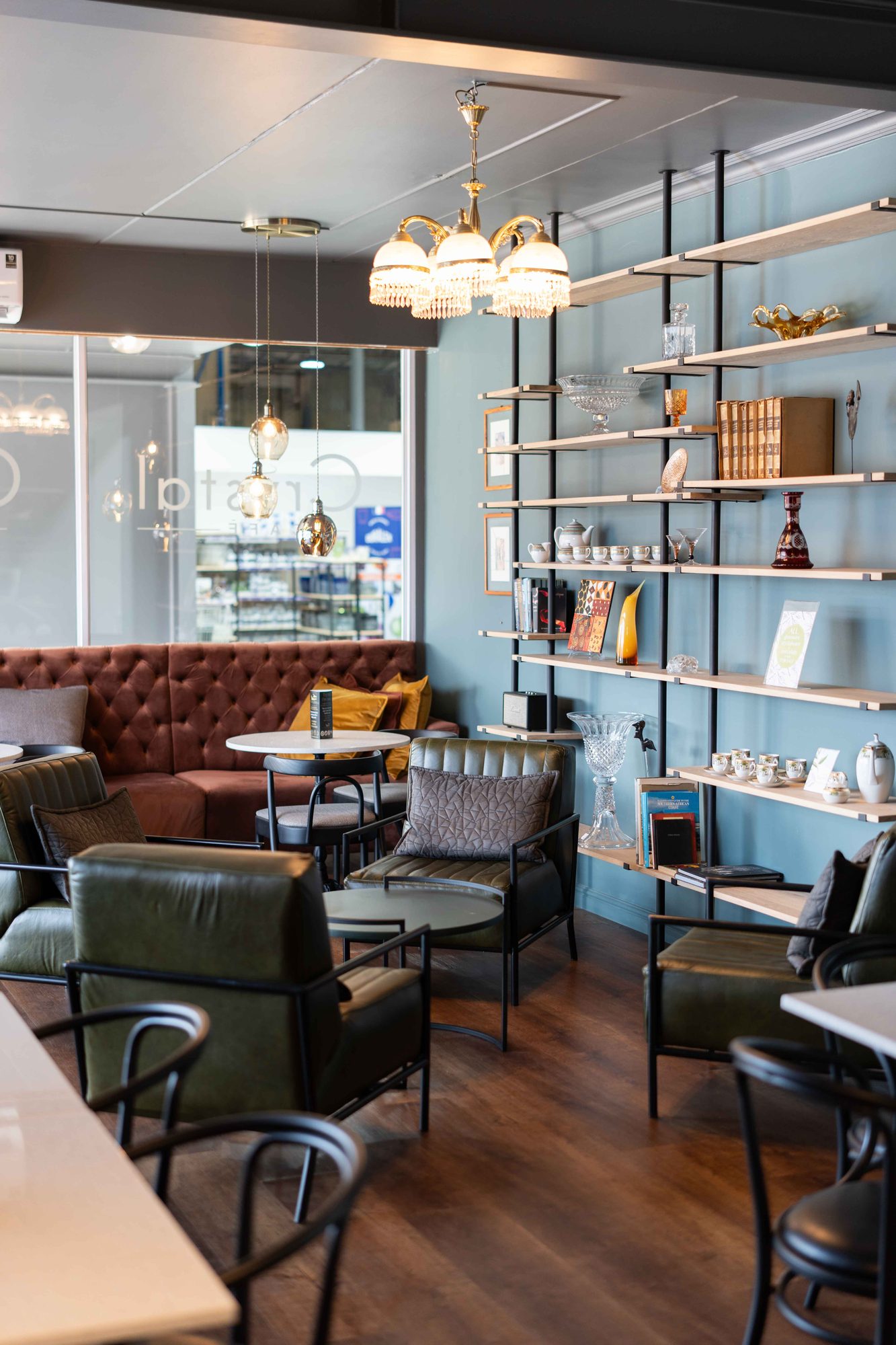 Green leather armchairs beside the display shelving in the cafe at Crystal Direct, by Nuwave