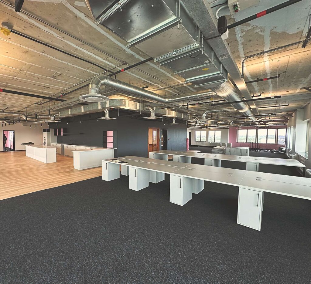 Open plan bench desks and the kitchen beyond at Polycat Visual Effects, by Nuwave