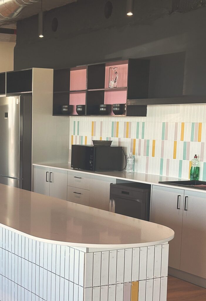 The tiled bar front and pastel splashback in the Polycat kitchen, built by Nuwave