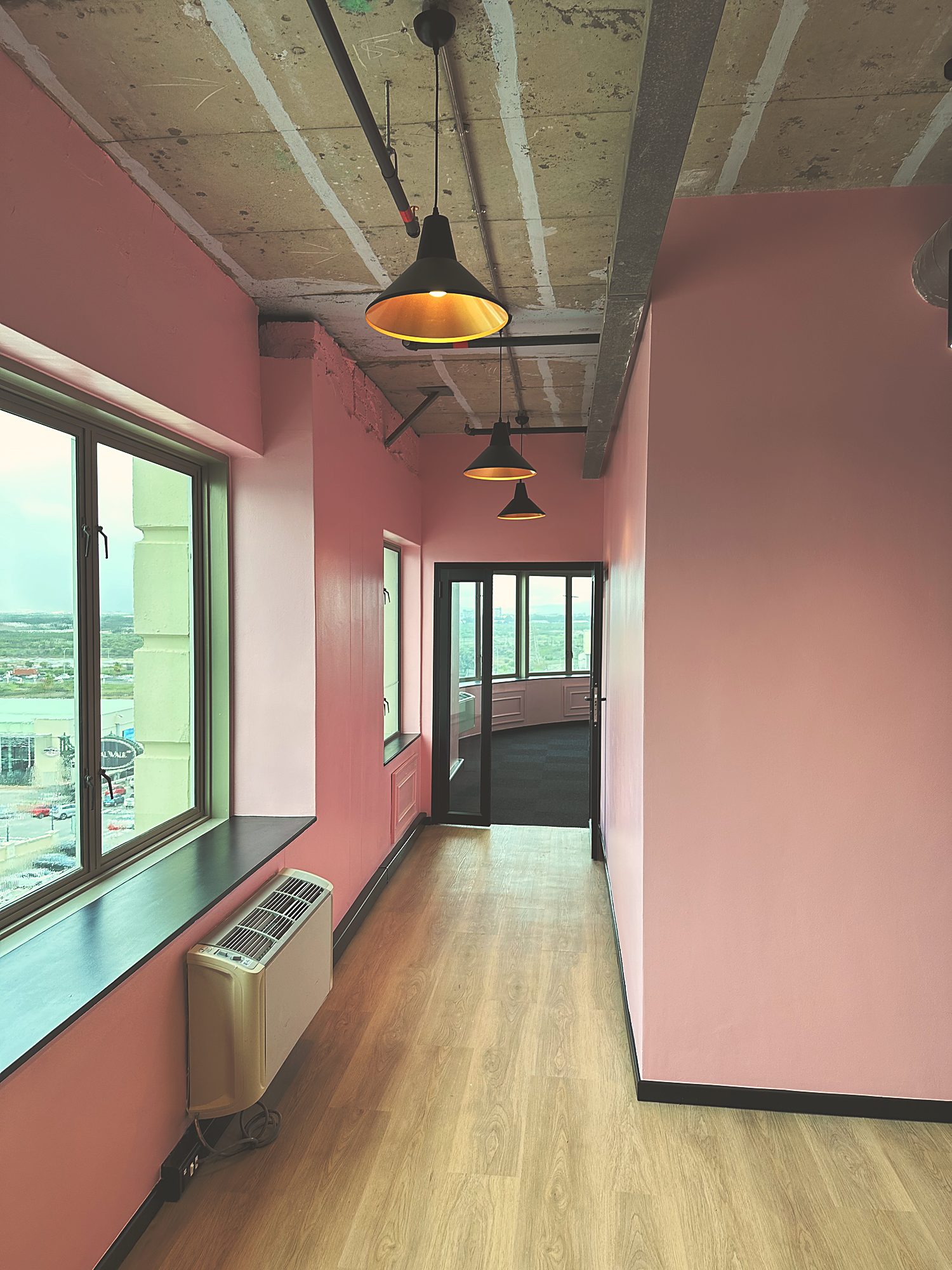 The pink corridor and timber floor between the studio suites at Polycat, by Nuwave