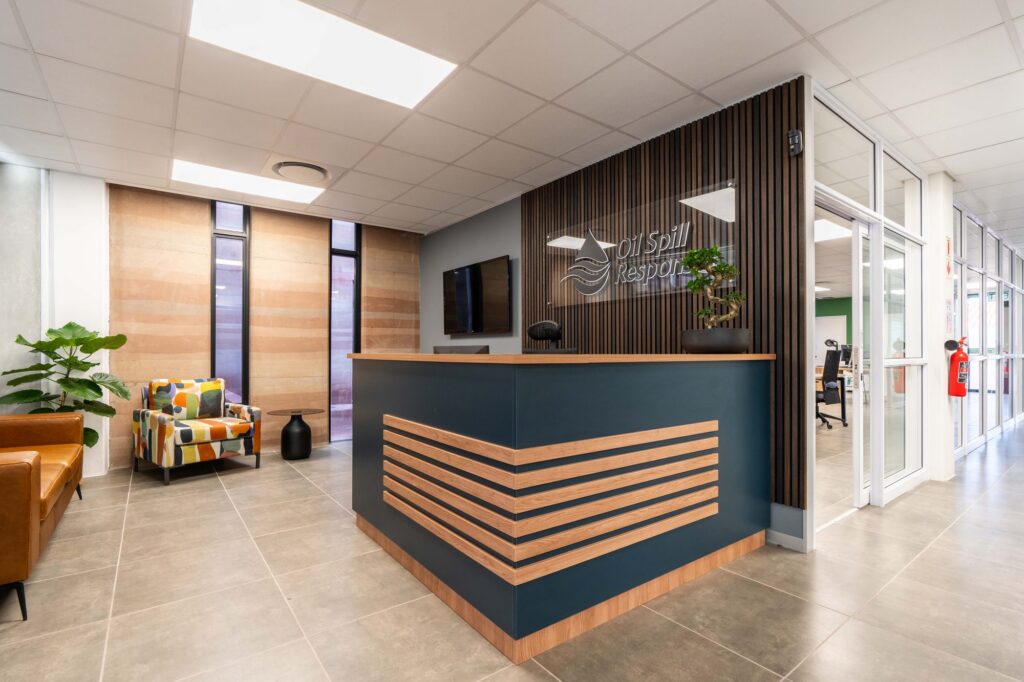 The navy and timber reception counter under the Oil Spill Response logo, installed by Nuwave
