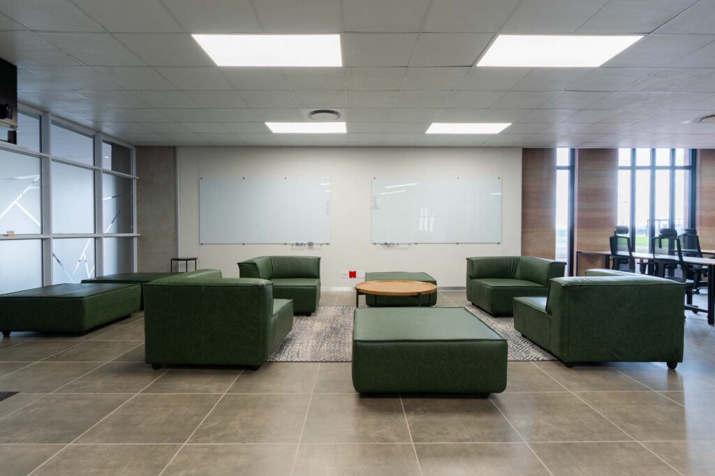 Green leather lounge modules with a round table in the breakout area at Oil Spill Response, by Nuwave