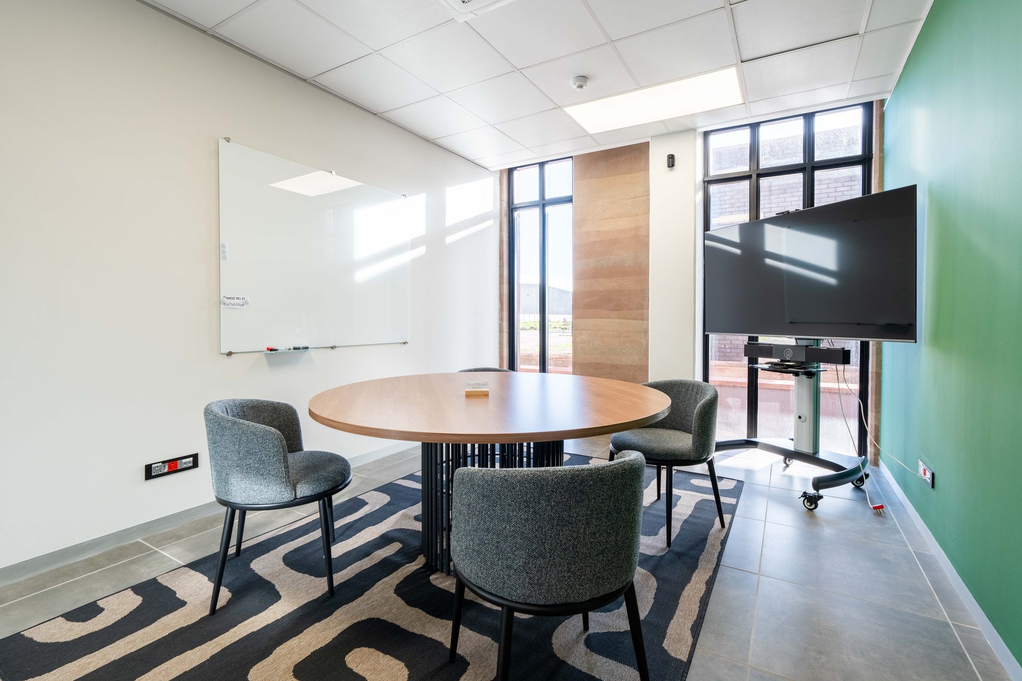 A round meeting table with grey chairs and a whiteboard at Oil Spill Response, by Nuwave