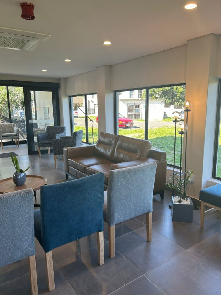 Blue waiting chairs beside the window at Cure Day Hospital, Bellville, furnished by Nuwave